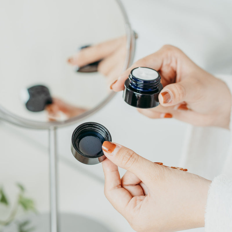 A small black childproof screw top glass jar.